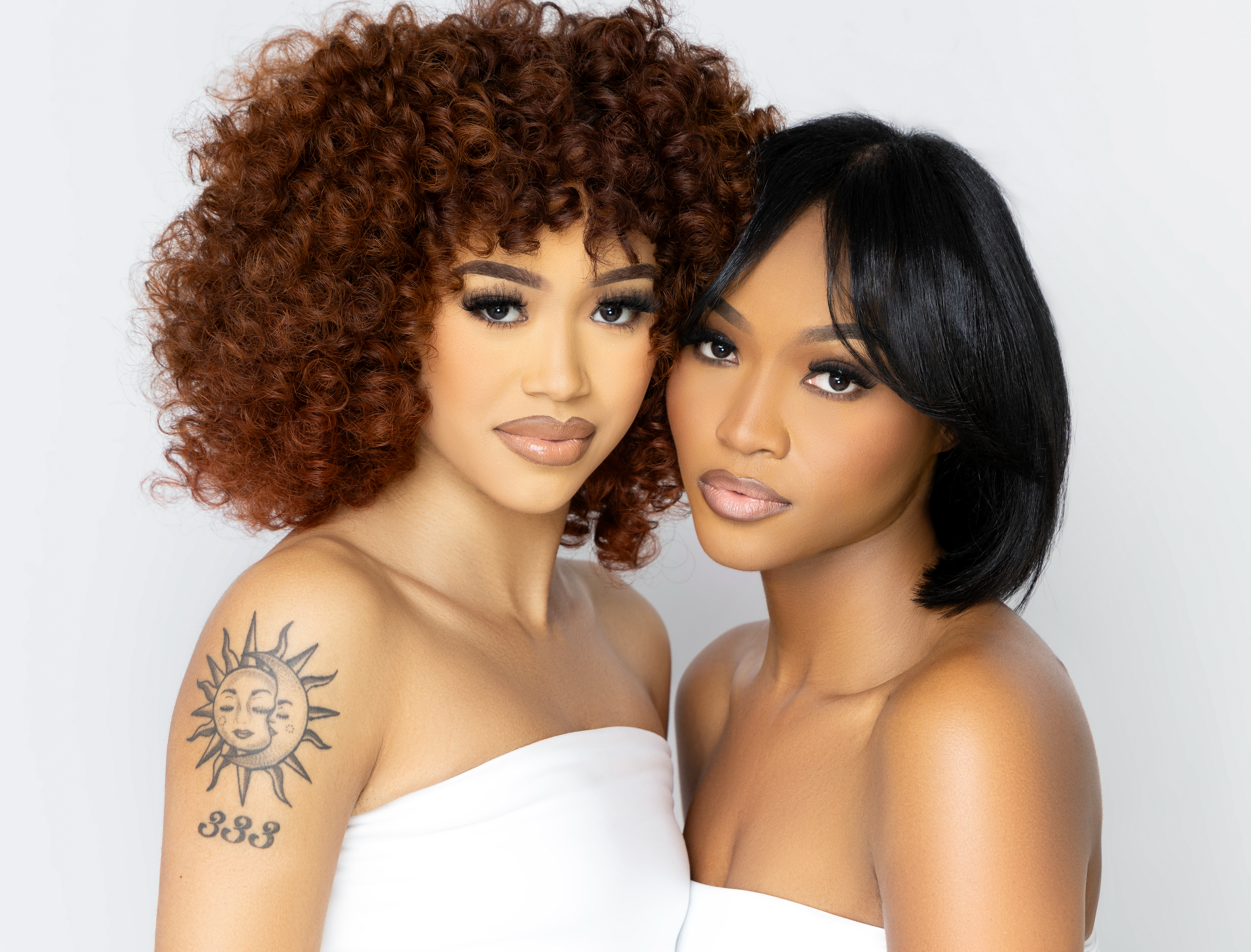 Two women with styled hair against a plain background